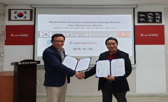 신우유비코스와 나노아이스 관계자가 계약체결후 악수를 하고 있다.(사진제공=신우유비코스)